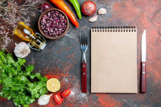 混合晚餐准备食物和豆子油瓶和一堆绿色柠檬西红柿和笔记本放在五颜六色的桌子上油盘子食物