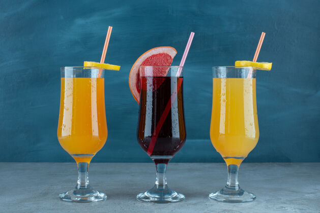 冷冻三种不同的果汁装在吸管玻璃杯里各种浆果新鲜