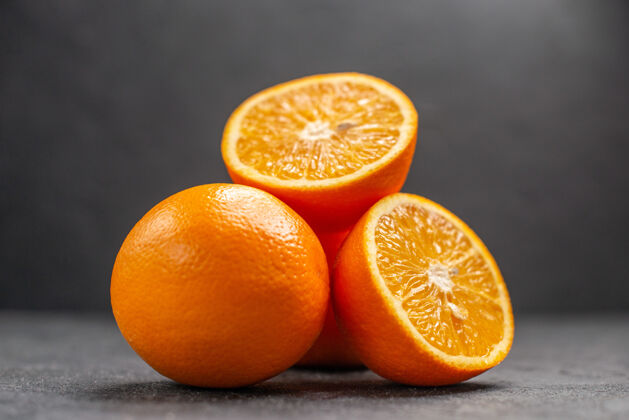 甜橙整个和切碎的新鲜橙子黑桌子的水平视图成熟脐橙水果