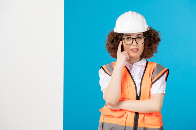 蓝色前视图蓝色墙上穿着制服的女建筑工人制服女性承包商