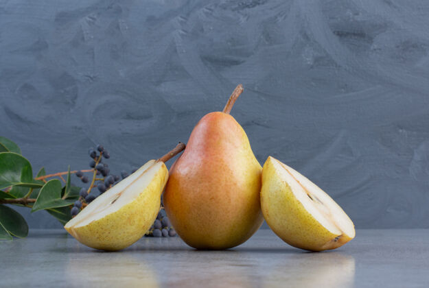美味在大理石背景上的装饰性树枝旁切一整块梨梨整体营养