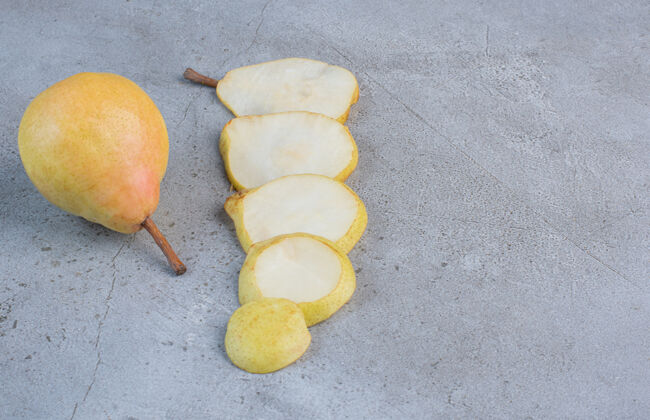 营养梨片排在大理石背景上的一整颗梨旁边配料饮食美味