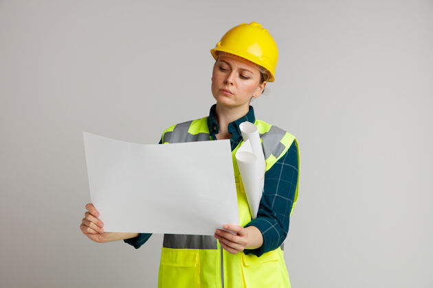 穿集中年轻的女建筑工人戴着安全帽和安全背心拿着证件看一眼女集中白色