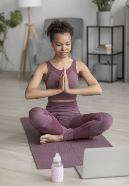 企业健身女士在家里用瑜伽垫做瑜伽电脑笔记本电脑姿势