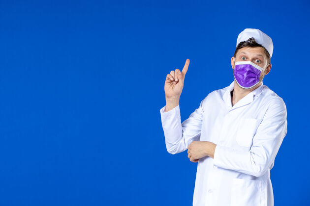 病毒身穿医疗服 戴着紫色面罩的男医生正对着蓝色的路边的人说话衣服有人旁听