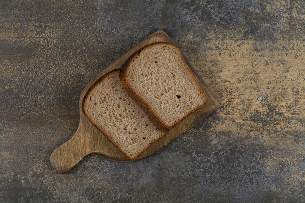 早餐木板上的黑吐司面包切片小吃面包皮