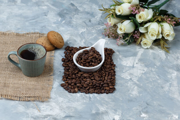 曲奇高角度观看咖啡豆在白色瓷罐饼干 咖啡杯 鲜花豆类咖啡烤