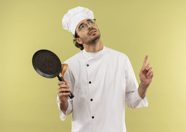 薯条看着抬头思考的年轻男厨师穿着厨师制服戴着眼镜拿着煎锅用勺子指着上来持有男人眼镜