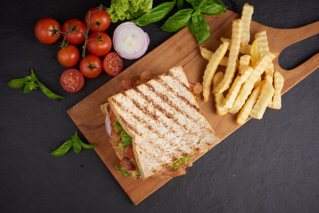 午餐烤制三明治 配培根 煎蛋 西红柿和生菜 放在木制砧板上蔬菜奶酪绿色