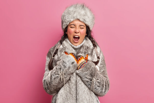 极地土生土长的女人打着哈欠 睡意朦胧 穿着冬装生活在格陵兰玫瑰色的墙上辫子毛皮个人