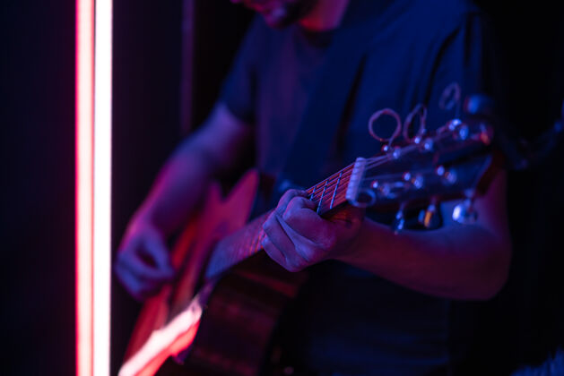 音乐会一个男人在黑暗的房间里弹原声吉他现场表演 原声音乐会艺术家人音乐家