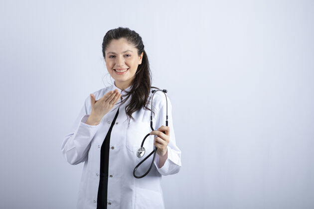 职业穿着白大褂的美丽女医生手持听诊器 面带微笑医生自信医生