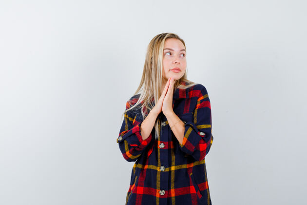 完美身穿格子衬衫的年轻女士手指并拢祈祷 神情平和 俯视前方祈祷模特衬衫
