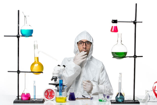 化学正面图穿着特殊防护服的男科学家围坐在办公桌旁 拿着解决方案科学实验室视图