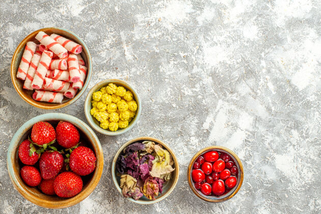 甜点顶视图新鲜的红色草莓和糖果在白色的表面水果甜糖果的颜色新鲜的红色草莓颜色浆果