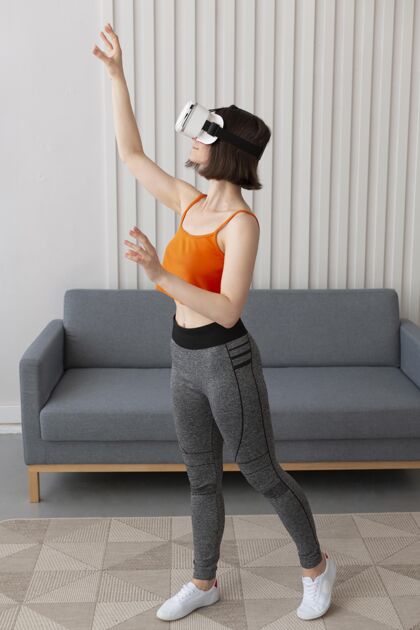 娱乐戴着虚拟现实护目镜玩电子游戏的年轻女子控制台游戏技术