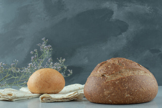 面包石桌上摆着各种各样的面包和洗手液新鲜不同有机