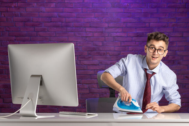 电脑前景办公室工作人员在办公桌后面熨领带紫色上班族办公室