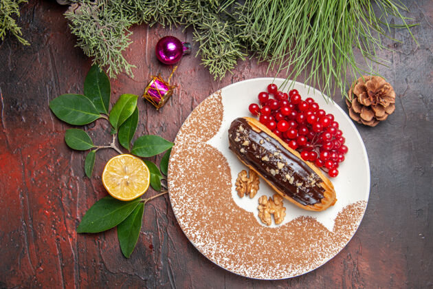 胡椒俯瞰美味的巧克力和红色浆果在黑暗的桌子上馅饼蛋糕甜点甜圣诞节食物顶部