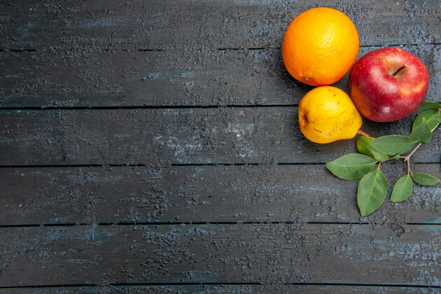 黑暗顶上看新鲜水果苹果梨和橘子 桌上深色水果新鲜成熟醇厚顶部新鲜水果金橘