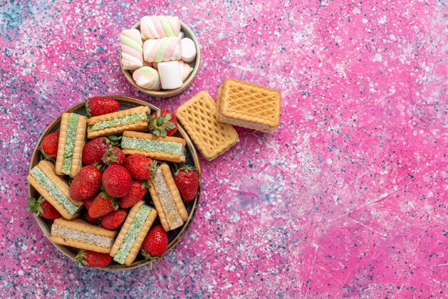 茶美味的华夫饼干顶视图 粉色表面有棉花糖和新鲜的红色草莓糖糖果华夫饼