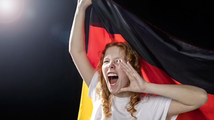 足球手持德国国旗的欢呼妇女的正视图比赛德国足球