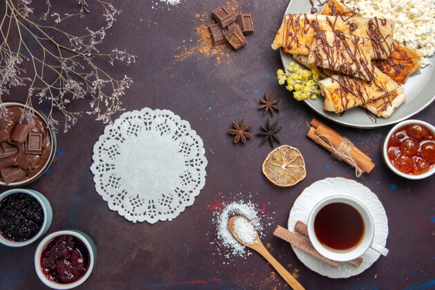 茶俯瞰美味的甜点 在黑暗的桌子上放一杯茶和果酱糕点饼干蛋糕糖甜茶生的糖食物