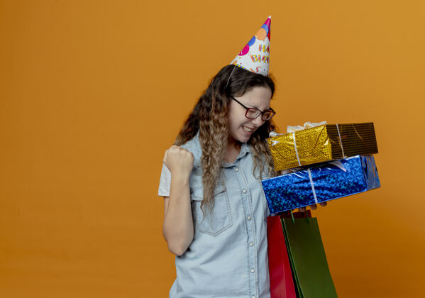 盒子一个戴着眼镜 戴着生日帽 手里拿着礼盒的快乐女孩快乐橙色举行