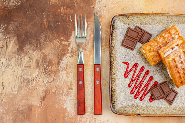 饼干俯瞰美味的华夫饼与巧克力条棕色背景巧克力抹刀背景