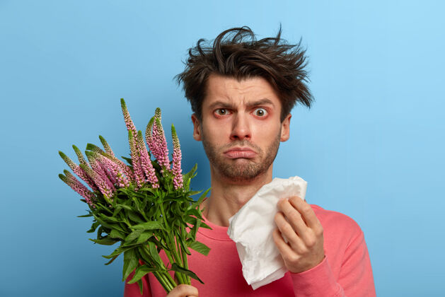 人不幸生病的年轻人有健康问题 用纸巾擦鼻子 打喷嚏和流泪 对季节性春天植物过敏 对开花过敏疼痛治疗发烧