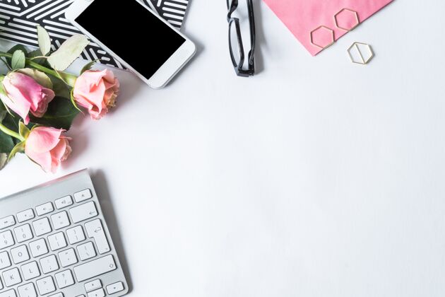 玫瑰键盘 智能手机 眼镜和白色表面的粉红玫瑰情人节表面笔记本