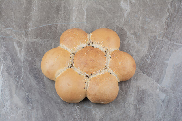 小麦大理石表面上的圆形白面包烘焙新鲜口味