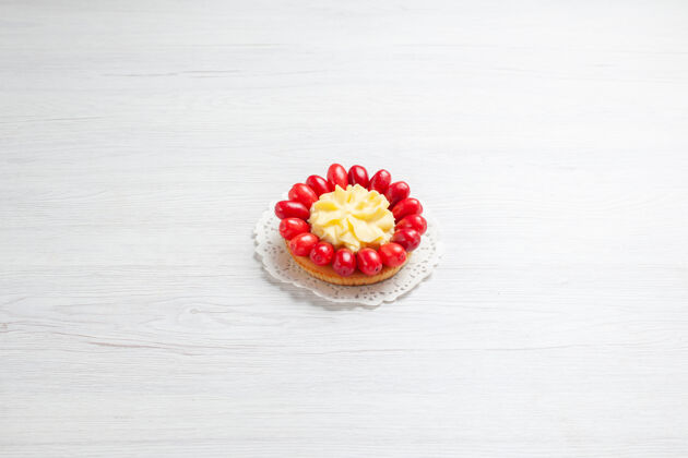 新鲜前视图小奶油蛋糕与山茱萸上的白色办公桌水果色奶油蛋糕甜点手镯水果浆果