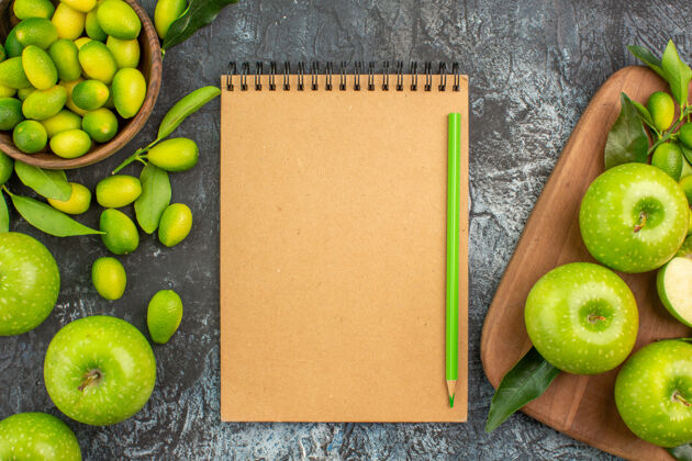 铅笔顶部特写查看苹果柑橘类水果绿色苹果与树叶板笔记本铅笔笔记本纸板健康