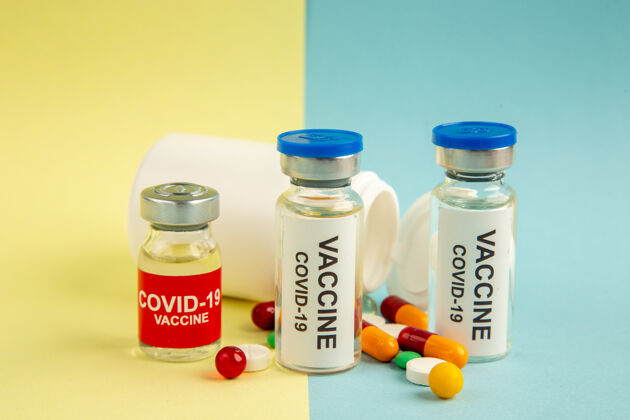 正面黄蓝色背景上不同药丸的抗covid疫苗的前视图实验室医院大流行