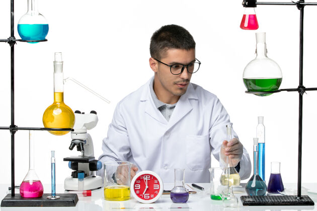病毒正面图身着白色医疗服的男性化学家在白色背景病毒科学实验室covid大流行上使用不同的解决方案医学大流行医生
