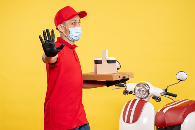 视图正面图男性快递员戴着口罩用黄色服务盒送咖啡-制服大流行色病毒工作正面流行颜色