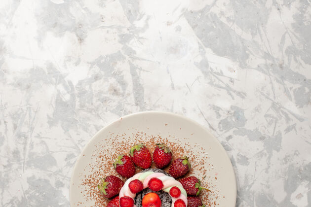 顶部顶视图新鲜的红色草莓和蛋糕在浅白色的空间生的健康饼干