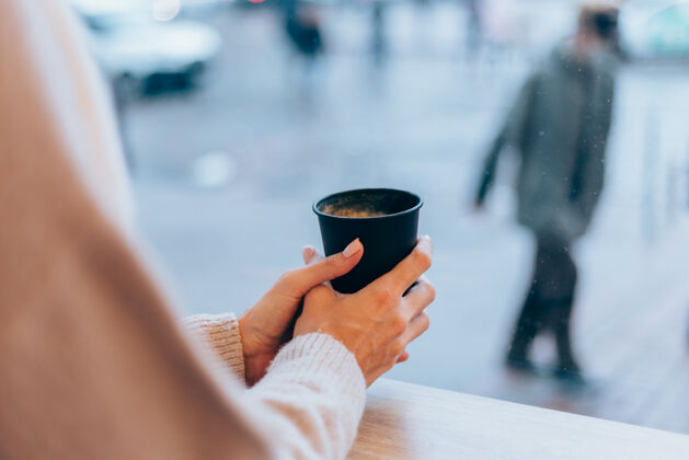 咖啡一个女孩在舒适的咖啡馆里用一杯热咖啡取暖热年轻女人