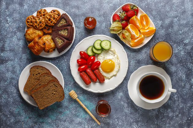 新鲜早餐盘子里有鸡尾酒香肠 煎蛋 樱桃番茄 糖果 水果和一杯桃子汁蔬菜水果营养