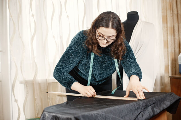 工作缝纫衣服的工具女人和眼镜一厘米长的女裁缝车间工作场所手