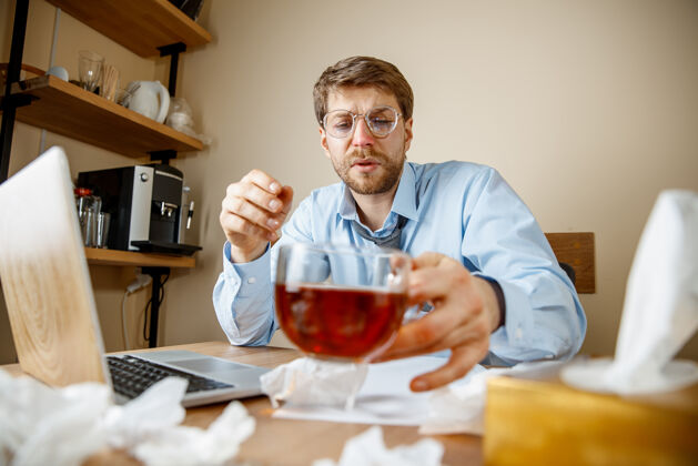 办公室感到恶心和疲倦在办公室工作的人喝一杯热茶 商人感冒 季节性流感大流行性流感 疾病预防 办公室空调引起疾病感冒工作高管