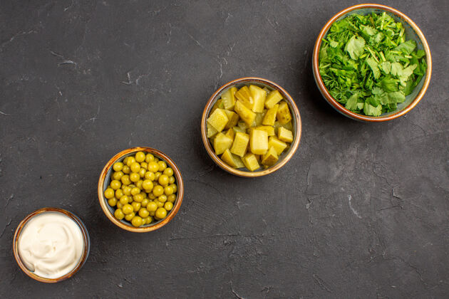 食用坚果俯视图的豆类和绿色不同的沙拉成分在黑暗的表面配料美味食物