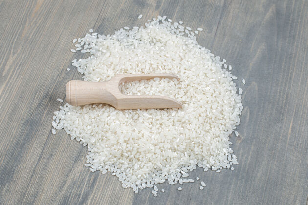 文化健康的生米用木勺放在木桌上大米干的有机