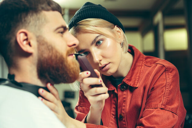 性别客户在理发店剃须女理发师在沙龙性别平等女性在男性职业毛巾胡子切割