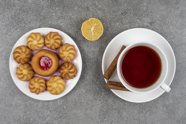 饼干一盘甜点和一杯茶放在大理石上美味柠檬糖果