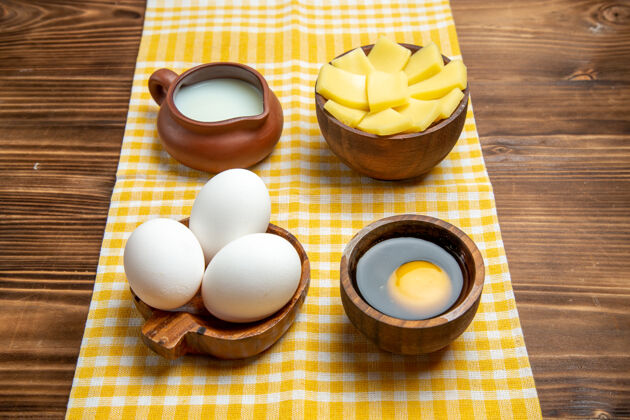 面团正面图生鸡蛋 木面上有奶酪和牛奶产品 生鸡蛋面团 生食物牛奶鸡蛋原料