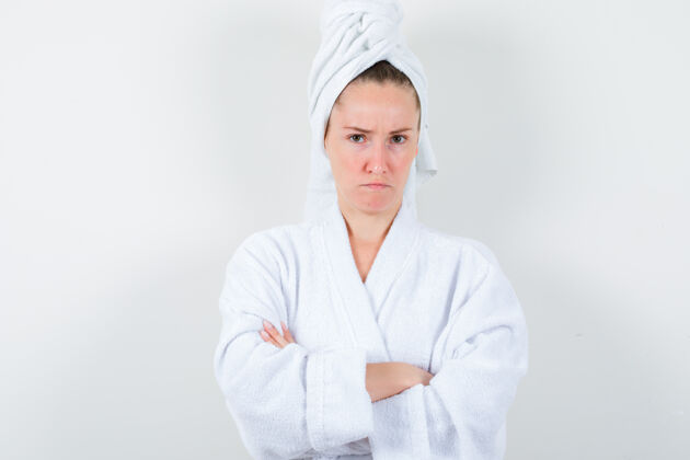 干净年轻的女士交叉着胳膊站在白色浴衣 毛巾和看愤恨前视图手臂头发浴袍