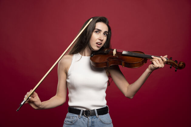 音乐年轻漂亮的女人拿着小提琴摆姿势演奏年轻人模特