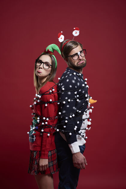 圣诞节笨手笨脚的夫妇对圣诞灯有问题时尚情侣悲伤
